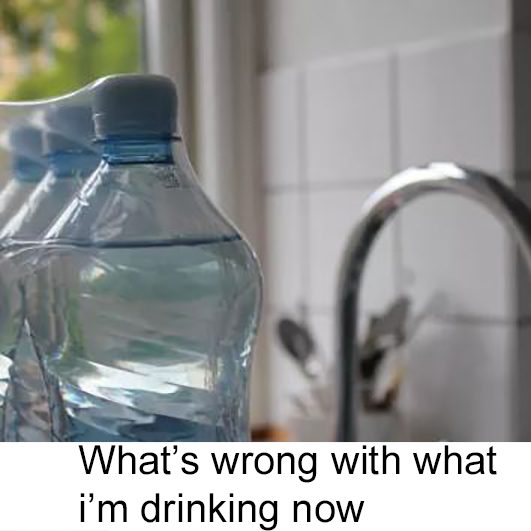 Plastic water bottles on kitchen countertop next to sink